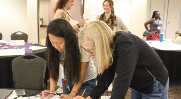 Two woman looking at poster together