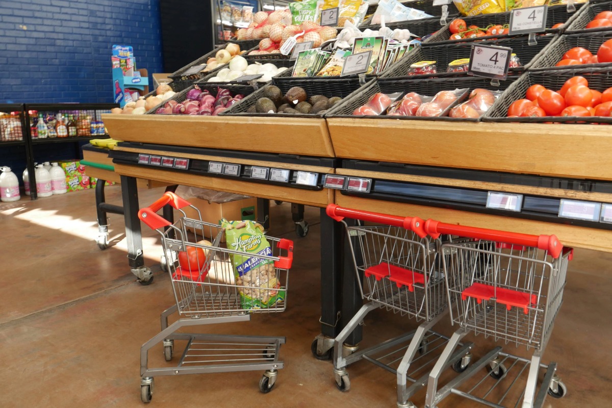 Grocery carts next to fresh produce in store